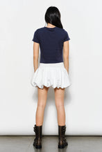 Load image into Gallery viewer, Person wearing a navy blue top and white skirt with black boots on a plain background
