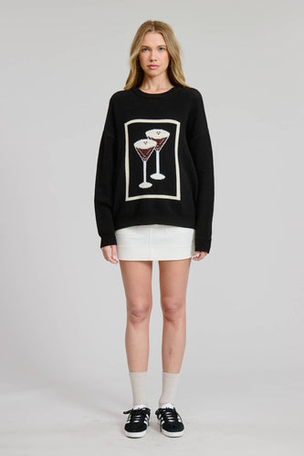 Person wearing a Glam Expressway black sweater with a martini glass design on a plain background