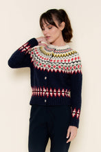 Load image into Gallery viewer, A woman wearing a navy blue Fair Isle cardigan sweater with red, green, yellow, and white patterned detailing across the chest, sleeves, and hem, styled against a neutral background.
