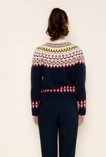 Load image into Gallery viewer, A woman wearing a navy blue Fair Isle cardigan sweater with red, green, yellow, and white patterned detailing across the chest, sleeves, and hem, styled against a neutral background.
