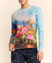 Load image into Gallery viewer, Sheer long sleeve mesh top with vibrant floral field print in soft focus colors, worn by a model.
