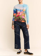 Load image into Gallery viewer, Sheer long sleeve mesh top with vibrant floral field print in soft focus colors, worn by a model.
