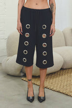 Load image into Gallery viewer, Black French terry Bermuda shorts with oversized silver grommet details, elastic drawstring waist, relaxed fit, and stretch fabric.
