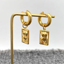 Load image into Gallery viewer, 18K gold-plated stainless steel huggie earrings with rectangular sculptural female body charms and a high-polish finish.
