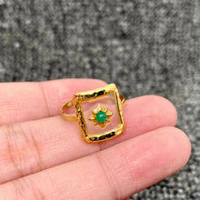 Load image into Gallery viewer, 18K gold-plated adjustable ring with a square translucent resin face, sculptural starburst design and green center accent.
