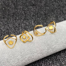 Load image into Gallery viewer, Set of gold rings with geometric designs on a textured surface
