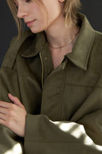 Load image into Gallery viewer, Person wearing a green jacket with a dark background

