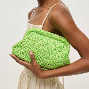 Person holding a green woven clutch bag against a neutral background.