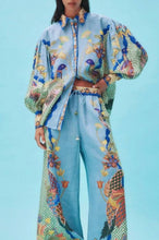 Load image into Gallery viewer, Elevate your style with our chic Birds of Paradise Loose Pants Set, featuring a stunning blue tropical motif adorned with Birds of Paradise. The set includes a feminine and sophisticated puff-sleeve top and matching pants, perfect for a coordinated look or stylishly worn as separates. Please note, the fit runs small, so consider sizing up for the perfect fit.
