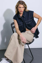 Load image into Gallery viewer, Introducing our stylish denim top, a versatile wardrobe essential. This trendy piece boasts a classic shirt collar and a convenient snap button-down front, making it both chic and easy to wear. The sleeveless design adds a touch of modern flair, perfect for warmer days or layering with your favorite jacket. Complete with front pockets for added functionality and style, this denim top effortlessly combines fashion and comfort for a timeless look.

