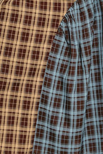 Load image into Gallery viewer, Sustainable recycled-fabric midi dress featuring contrasting brown and blue plaid panels, a sleeveless silhouette and asymmetrical draped design.

