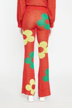 Load image into Gallery viewer, Like its matching sweater, the Red Glitter Floral Knit Pants are attention-grabbing with their metallic sheen and fun print. These cherry red knit pants have a yellow and green floral print, a subtle shimmer and lots of stretch.
