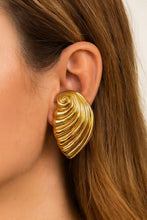 Load image into Gallery viewer, Gold shell-shaped earring worn by a person with brown hair.
