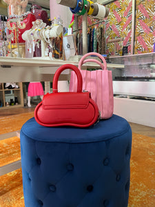 Meet our Cherry Red Structured Bag, the epitome of fashion and sustainability. This small round-top handle bag, made from recycled vegan leather, is your eco-conscious style statement. Wear it comfortably as a crossbody bag using the adjustable strap for hands-free convenience.