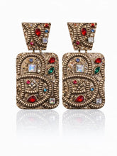 Load image into Gallery viewer, Ornate gold drop statement earrings with embossed texture and multicolor gemstone accents in red, green, blue, and crystal tones.
