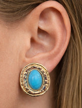 Load image into Gallery viewer, Large oval turquoise and gold statement stud earrings worn on ear showing bold size and textured gold detailing.


