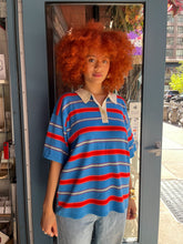 Load image into Gallery viewer, Short-sleeve multicolored striped polo shirt with red, blue, and cream stripes, soft knit fabric, and contrasting cream collar - stylish and comfortable women’s preppy polo top, perfect for summer outfits, easy casual wear, or elevated everyday fashion; available now at Glam Expressway.
