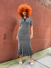 Load image into Gallery viewer, Person wearing a black and white striped dress on a sidewalk.
