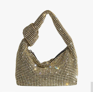 Add some sparkle to your holiday look with the Gold Crystal Evening Bag. Made with crystals and a top handle, this stylish bag features a shiny, bling-inspired silhouette that is sure to add some extra glamour to any occasion.