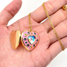 Load image into Gallery viewer, Open pink enamel heart locket necklace with colorful cubic zirconia stones, crystal heart centerpiece and gold-plated chain.
