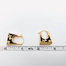Load image into Gallery viewer, Black enamel handbag-shaped huggie earrings with gold-tone trim and delicate carved floral details.
