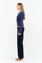 Load image into Gallery viewer, Model wearing The Aspen Double Zip Knit Cardigan in navy with contrast fuzzy trim, double zipper, flared sleeves, and wide-leg dark wash jeans.
