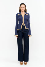 Load image into Gallery viewer, Model wearing The Aspen Double Zip Knit Cardigan in navy with contrast fuzzy trim, double zipper, flared sleeves, and wide-leg dark wash jeans.
