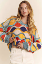 Load image into Gallery viewer, Woman wearing a colorful, patterned sweater against a plain background

