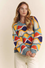 Load image into Gallery viewer, Woman wearing a colorful patterned sweater against a plain background
