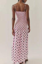Load image into Gallery viewer, Pink polka dot midi dress with a smocked bodice, thin straps, and a flowy skirt, worn by a model.
