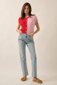 Woman wearing a red and pink button-up shirt with light blue jeans on a beige background