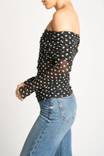 Load image into Gallery viewer, Woman wearing a black polka dot top and blue jeans on a white background
