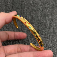 Load image into Gallery viewer, 18K gold-plated open cuff bracelet with tiny multicolored cubic zirconia stones set in scattered star-shaped details.
