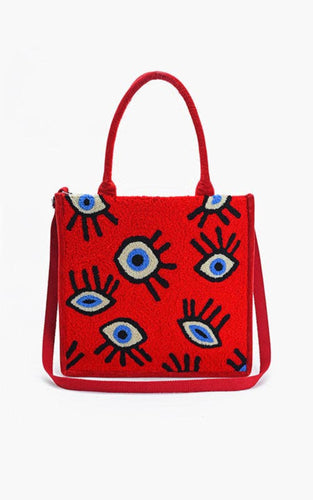 Red handbag with all seeing eye pattern on a white background.