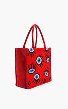 Load image into Gallery viewer, Red tote bag with black and blue eye designs on a white background
