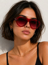 Load image into Gallery viewer, Woman wearing red sunglasses against a white background
