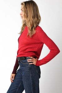 Woman wearing a crimson red sweater and blue jeans from Glam Expressway.