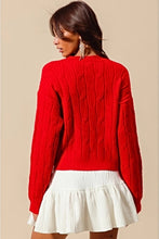 Load image into Gallery viewer, Add a playful pop of color to your wardrobe with our Cherry Red Cable Knit Sweater, adorned with delicate white ribbon bow appliqués! This cozy yet statement-making sweater features a classic cable knit design in a bold red hue, with charming white bows adding a whimsical touch. Perfect for pairing with jeans or a skirt, this sweater will keep you warm and stylish all season long. Available in sizes S to XL for the perfect fit!
