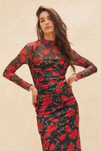 Load image into Gallery viewer, Woman wearing a black skirt and matching top with red floral pattern against a beige background
