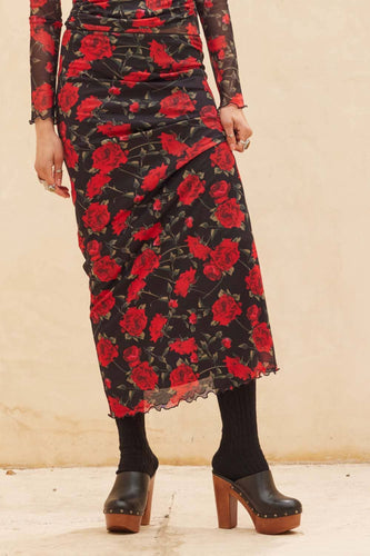 Person wearing Glam Expressway's Rose Print Maxi Skirt against a beige background