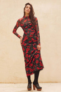Woman wearing a black and red floral dress against a beige background