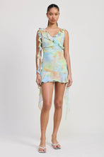 Load image into Gallery viewer, Model wearing a colorful dress with ruffled sleeves on a white background

