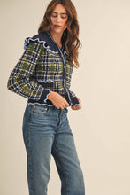 Load image into Gallery viewer, Model wearing a ruffled plaid knit cardigan with puff sleeves, scalloped trim, button-front V neckline, and contrast cable-knit yoke, styled with denim jeans.
