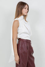Load image into Gallery viewer, Woman wearing an ivory satin one-shoulder asymmetrical blouse with draped scarf detail paired with burgundy leather pants
