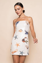 Load image into Gallery viewer, Model wearing a strapless white sequin mini dress featuring ocean-inspired seashell, starfish, and seahorse embellishments in a fitted bodycon silhouette.
