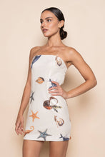 Load image into Gallery viewer, Model wearing a strapless white sequin mini dress featuring ocean-inspired seashell, starfish, and seahorse embellishments in a fitted bodycon silhouette.
