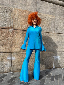 Person wearing a blue outfit standing on a stone pavement