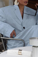 Load image into Gallery viewer, Woman wearing a sky blue cropped blazer and matching relaxed balloon pants styled with heels and a white clutch.
