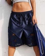 Load image into Gallery viewer, Navy blue shorts with lace detailing worn by a person against a white background

