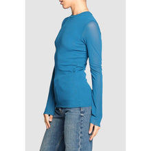 Load image into Gallery viewer, Blue long-sleeve top with sheer sleeves worn by a person on a light gray background

